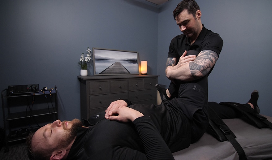 man performing a chiropractic adjustment on patients leg